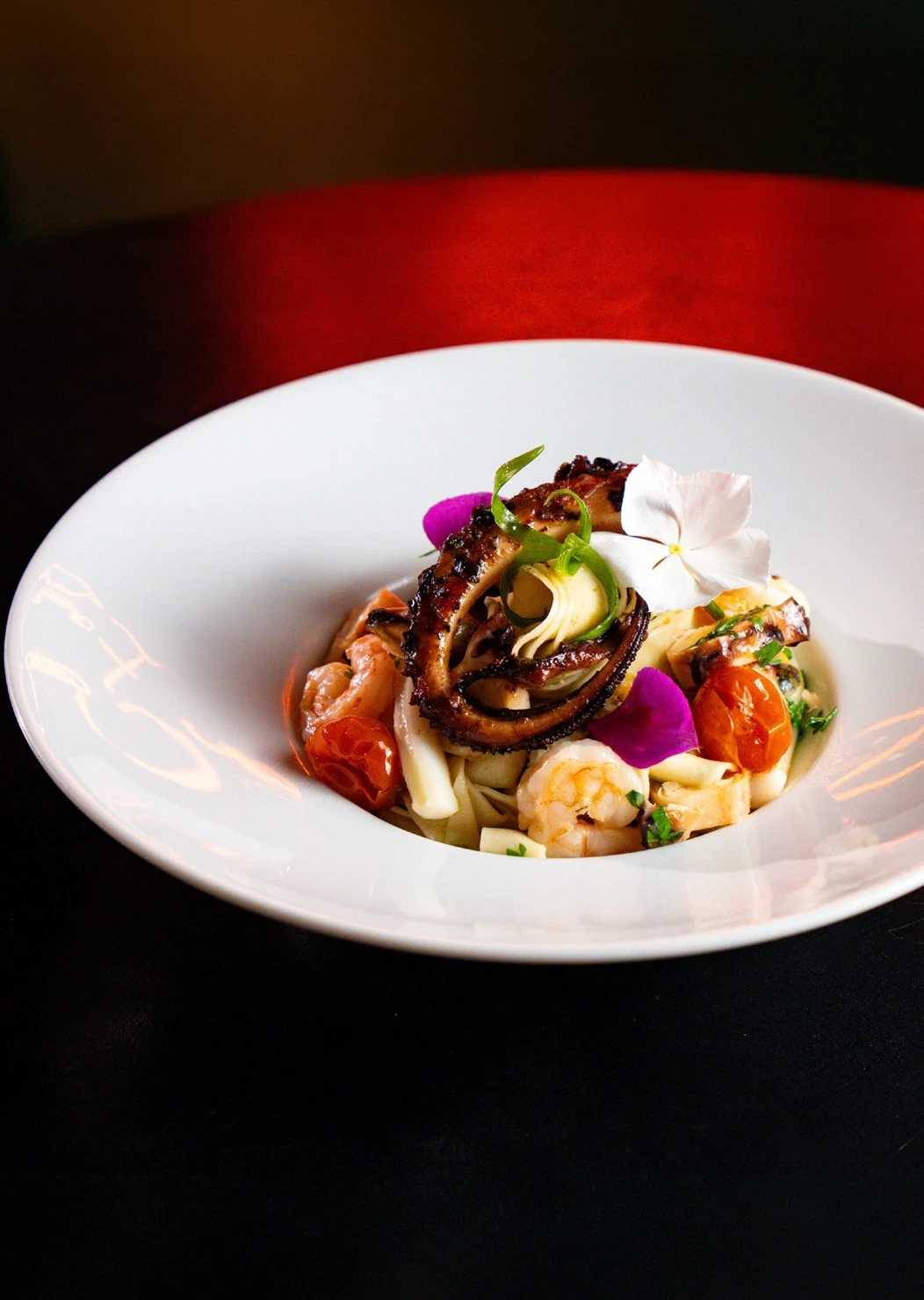 Fettuccine com camarões e frutos do mar em prato branco